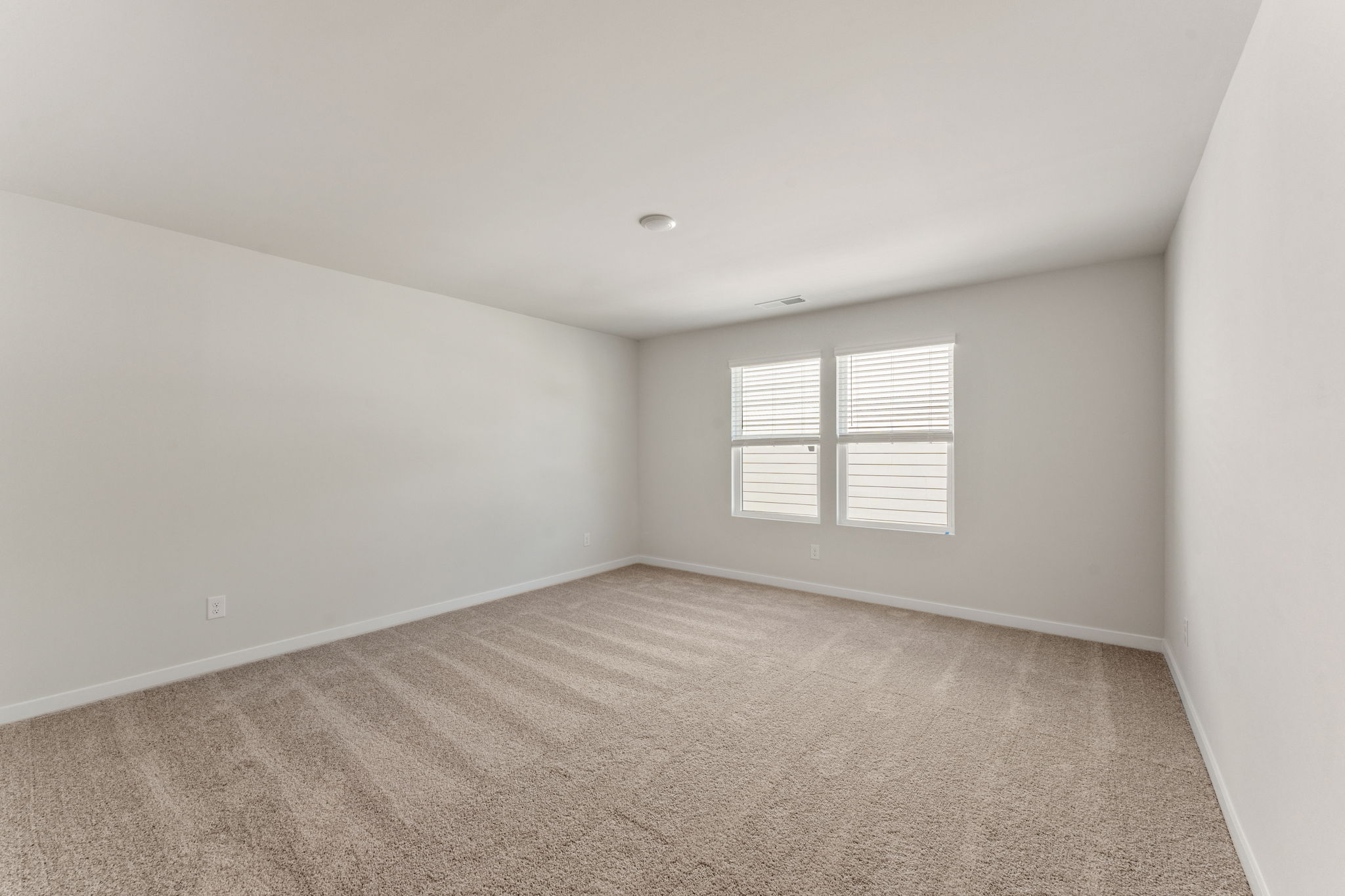 A room with a carpet and a window.