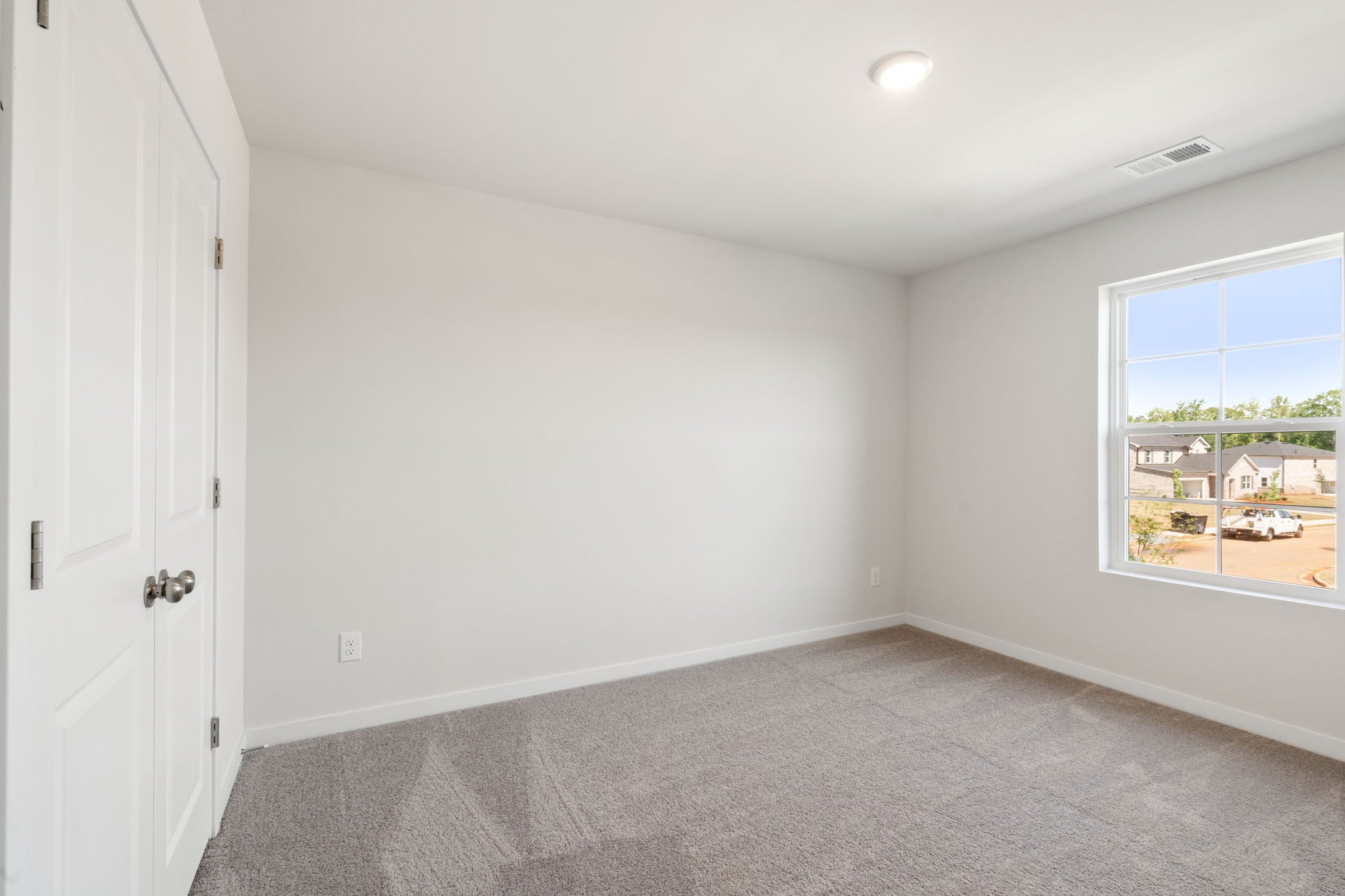 A room with a carpet and a window.