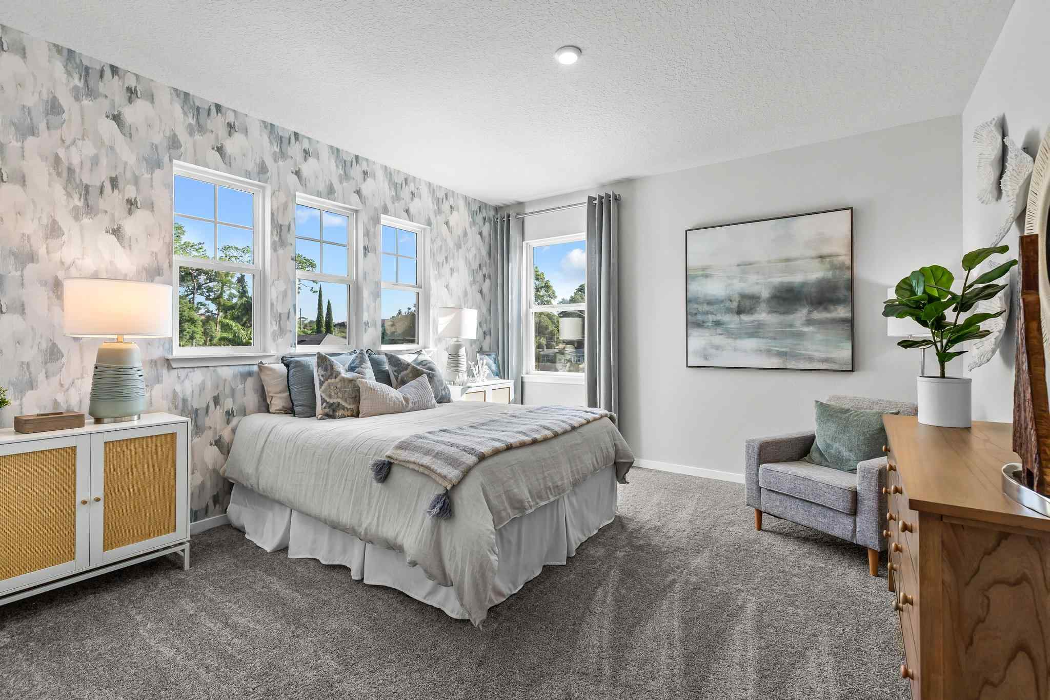 A bedroom with a bed and a chair.