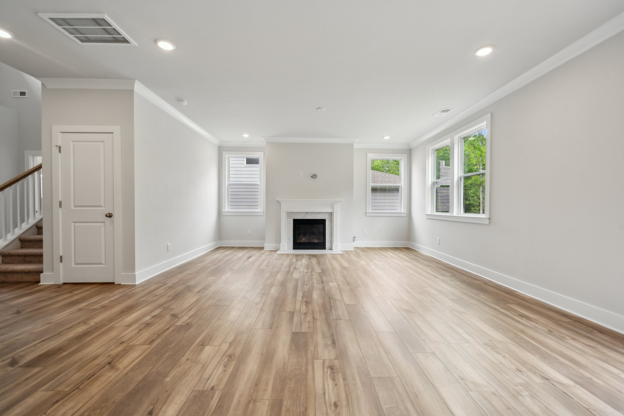 A room with a fireplace and wood floors.