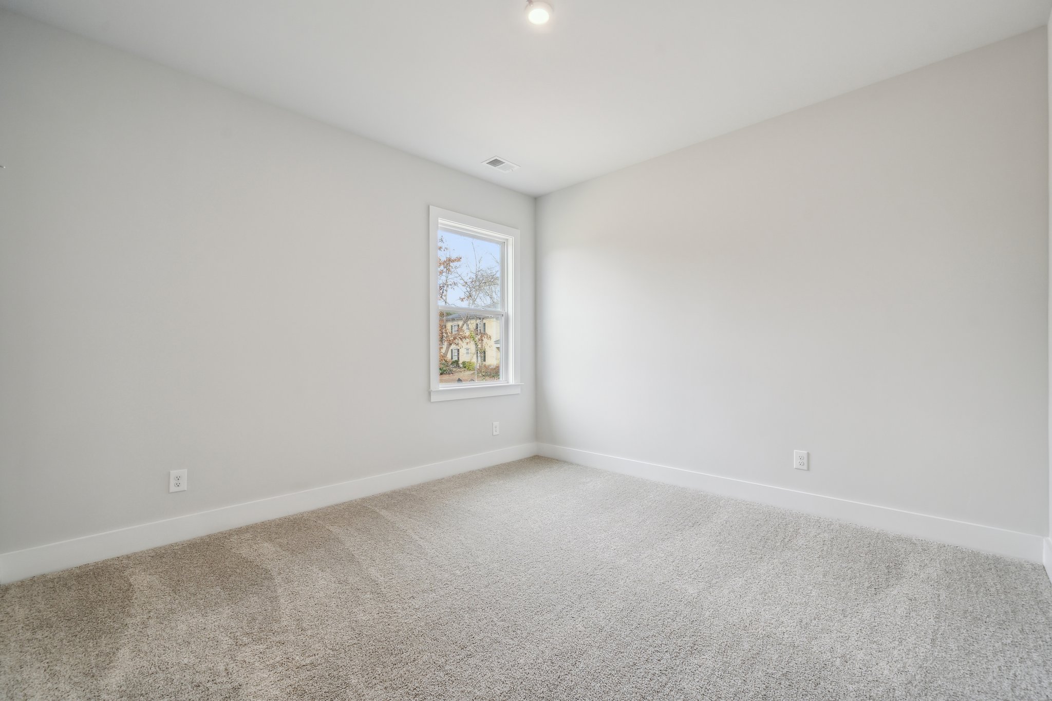 A room with a window and carpet.