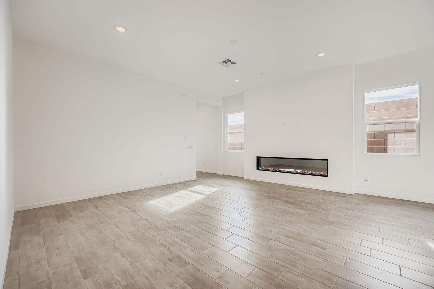A room with a wood floor and a fireplace.