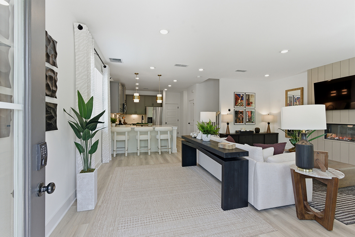 A large room with a large white couch and a black table.