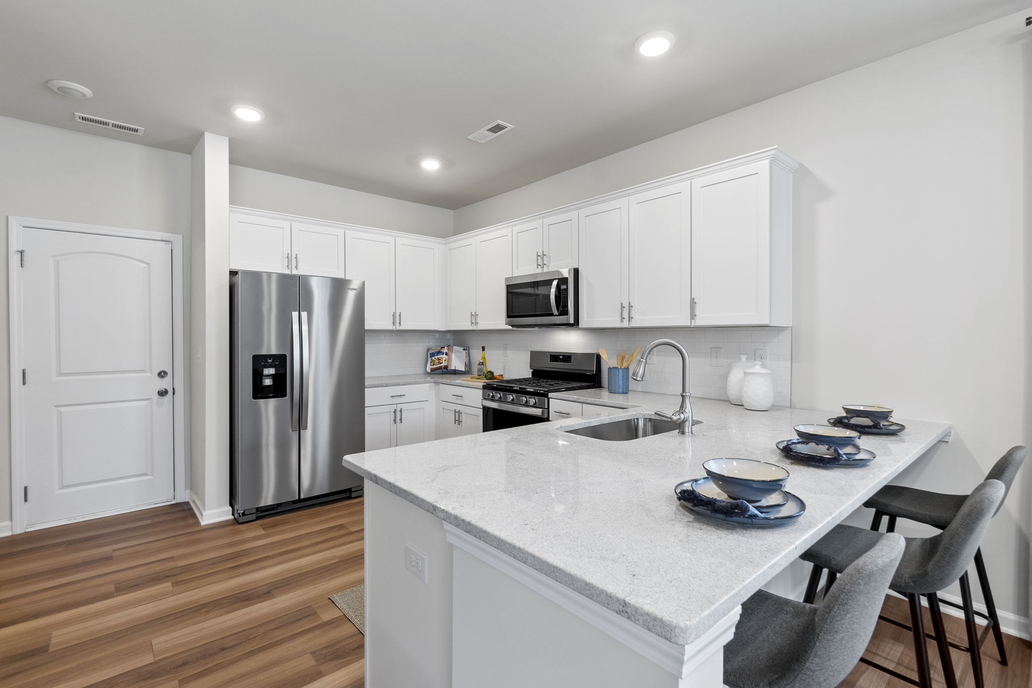 A kitchen with white cabinets.