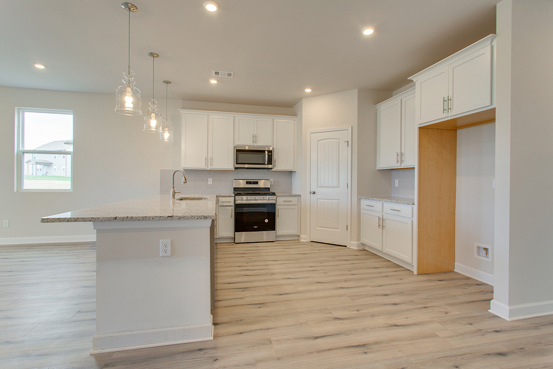 A kitchen with white cabinets.
