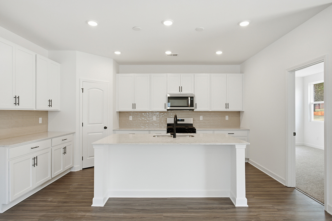 A kitchen with white cabinets.