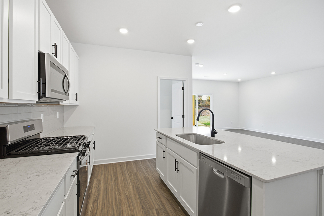 A kitchen with white cabinets.