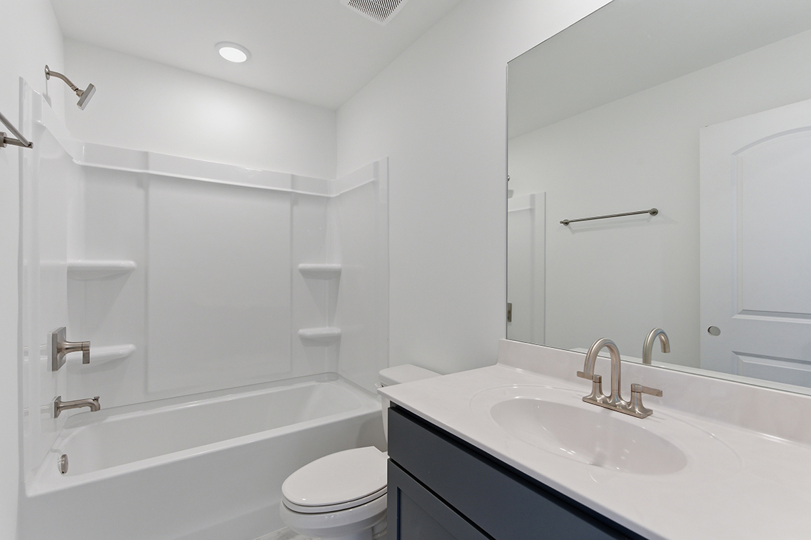 A bathroom with a tub sink and toilet.