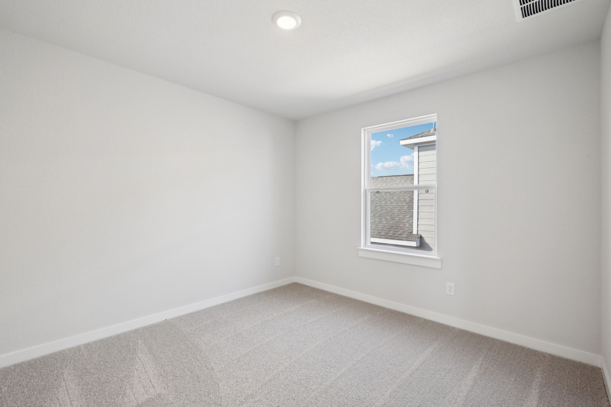 A room with a window and a carpet.