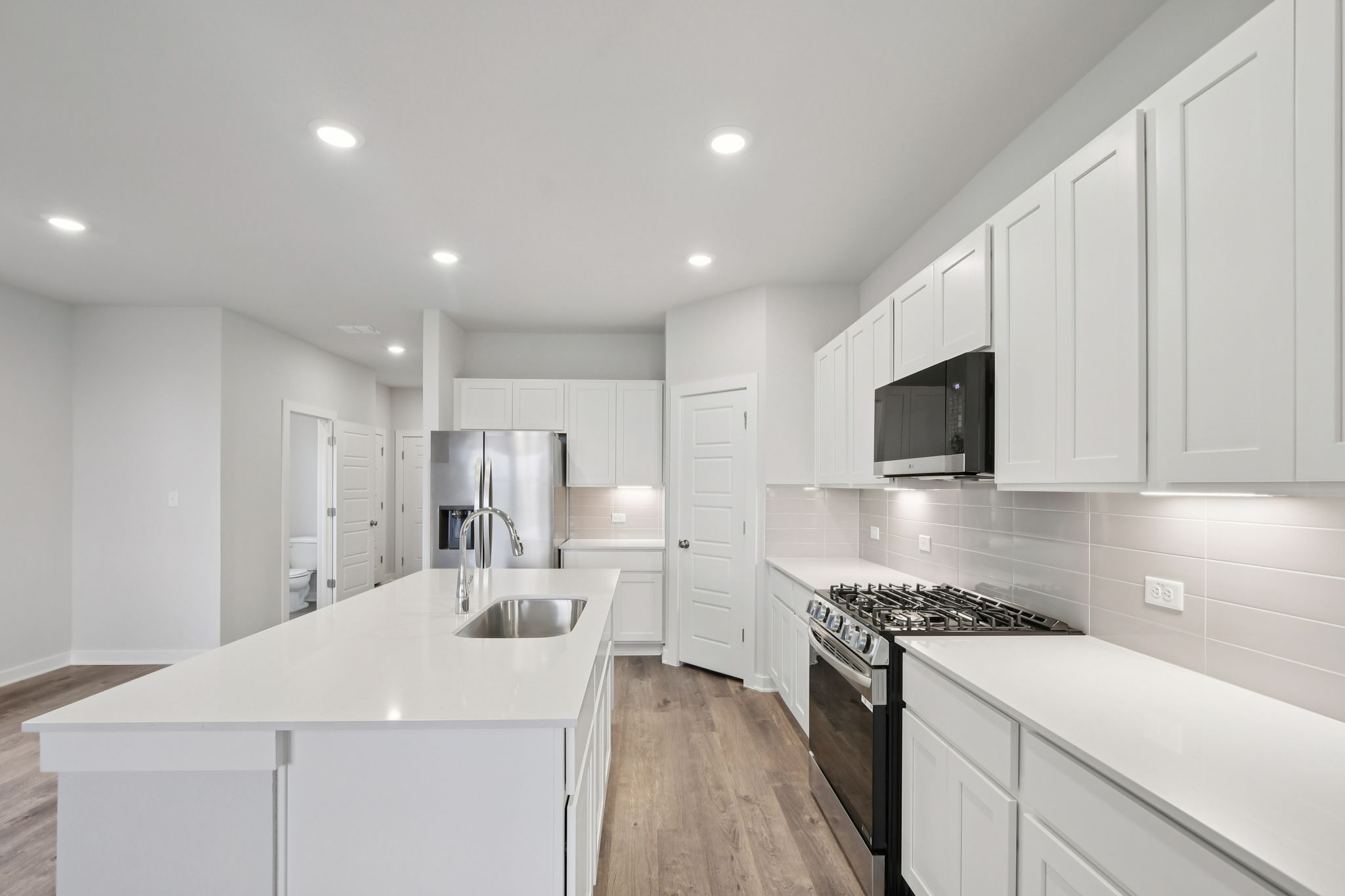 A kitchen with white cabinets.
