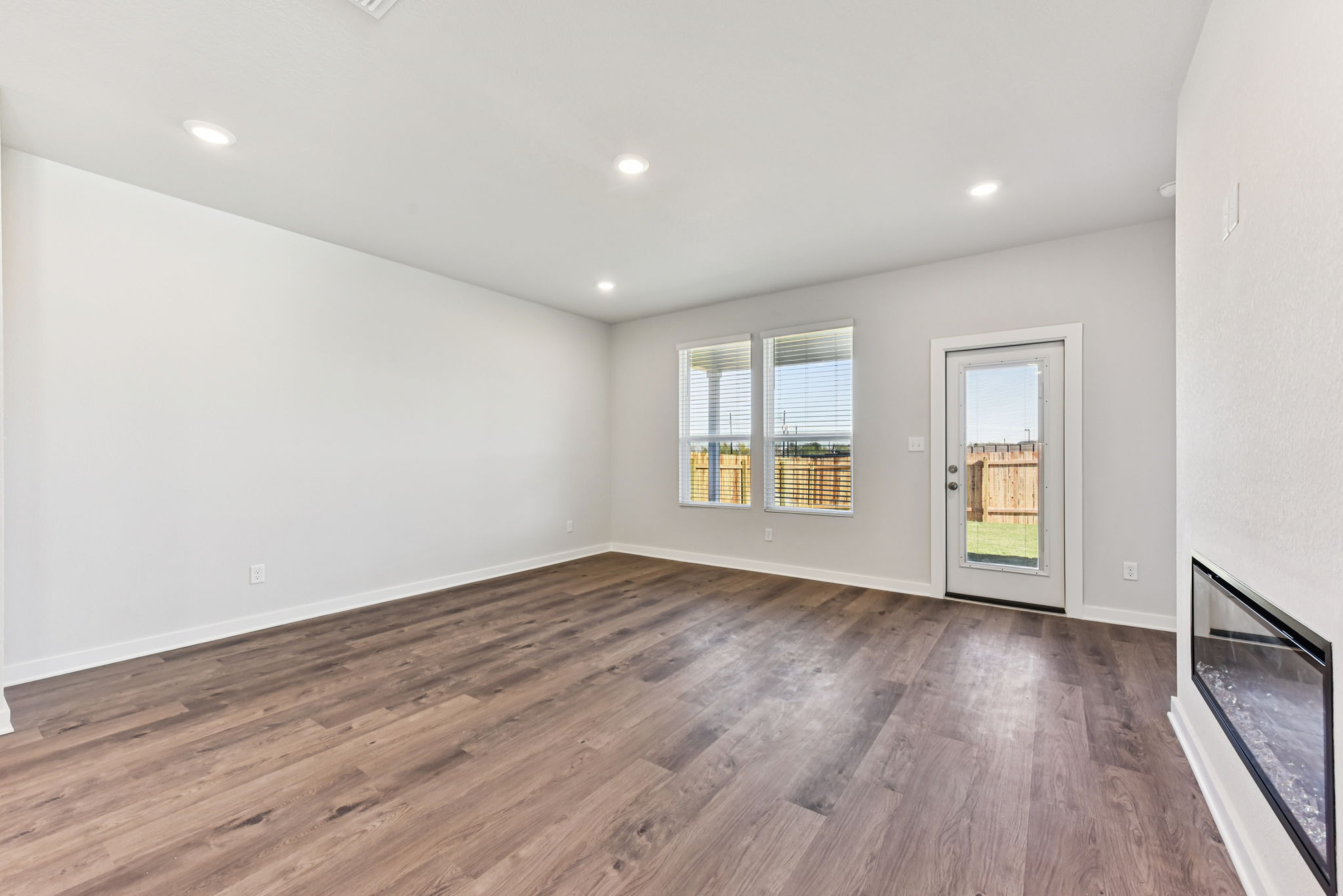 A room with a wood floor and windows.