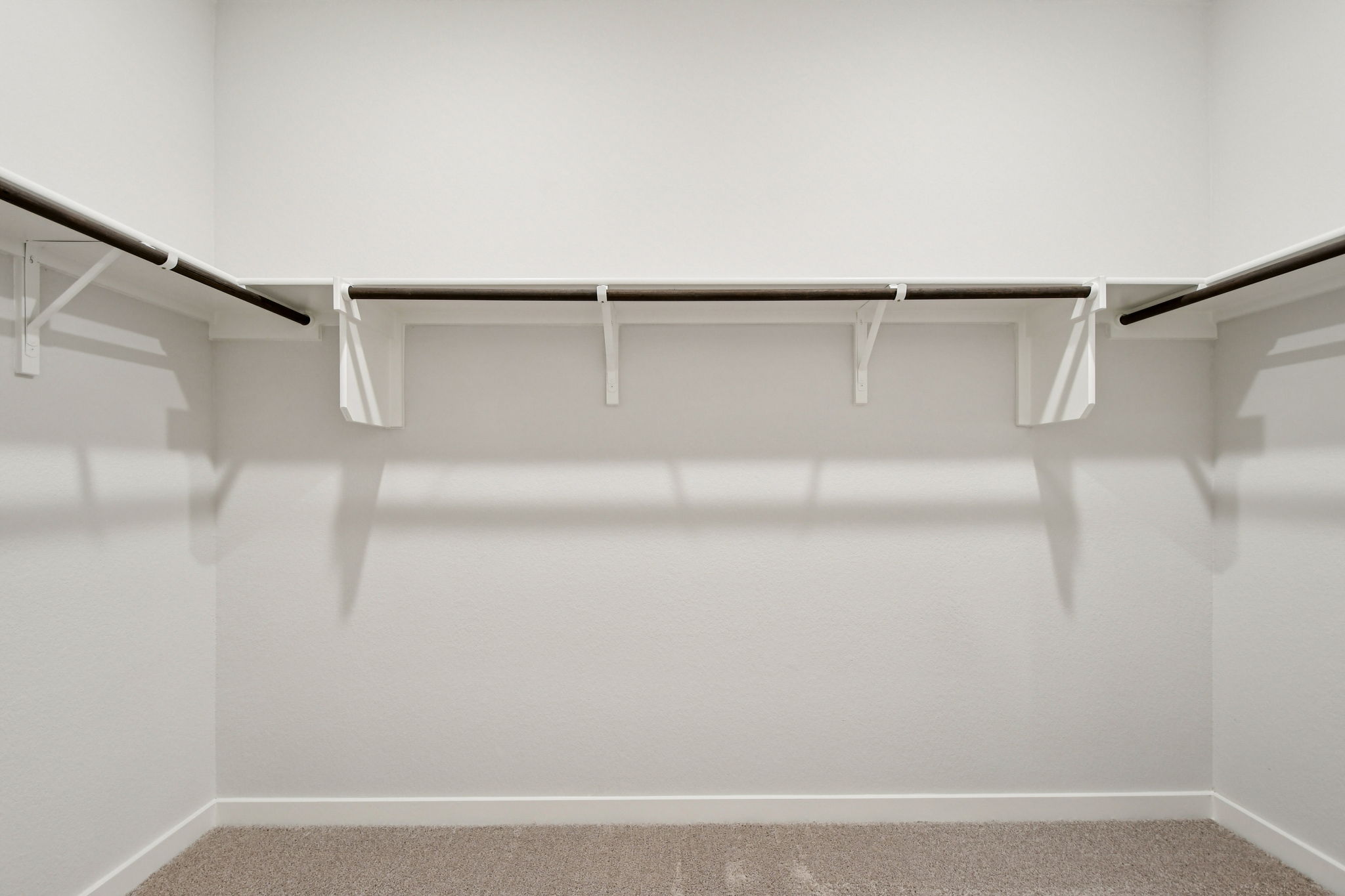 A white wall with a metal bar.