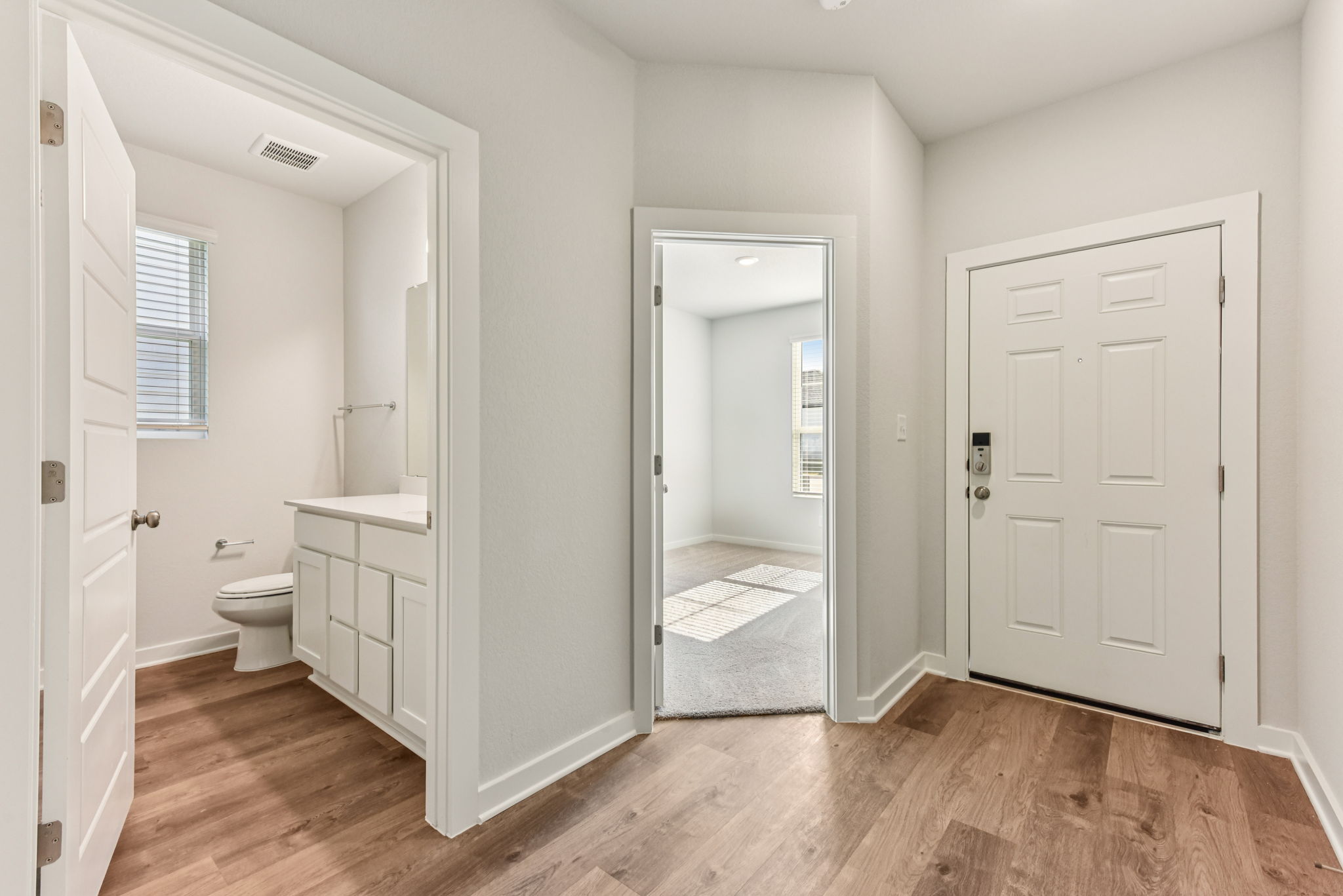 A bathroom with white cabinets.