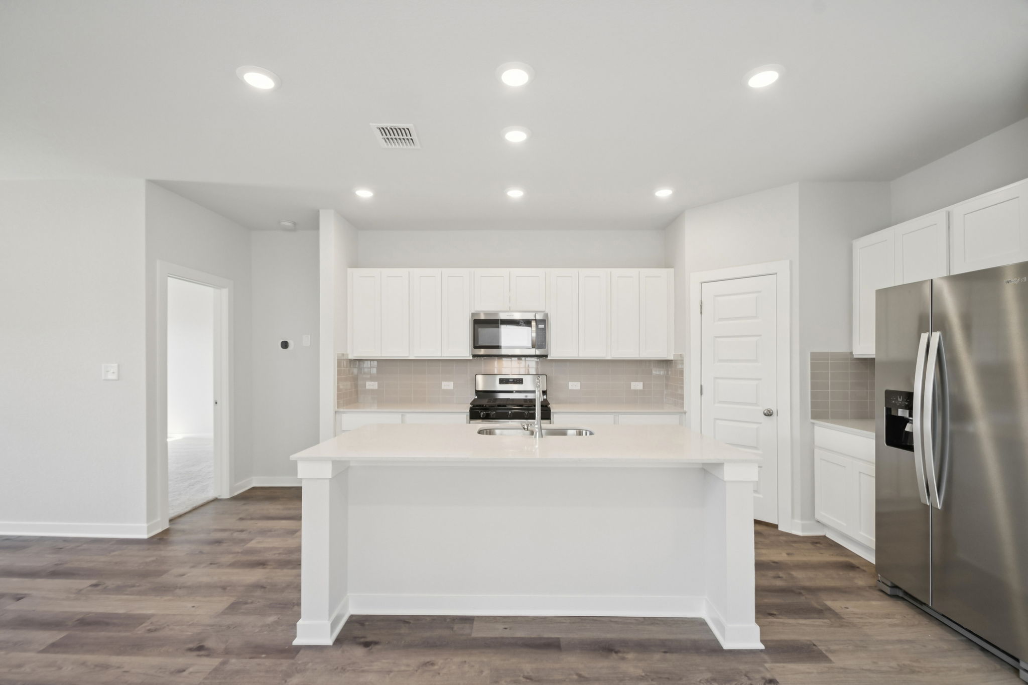 A kitchen with white cabinets.