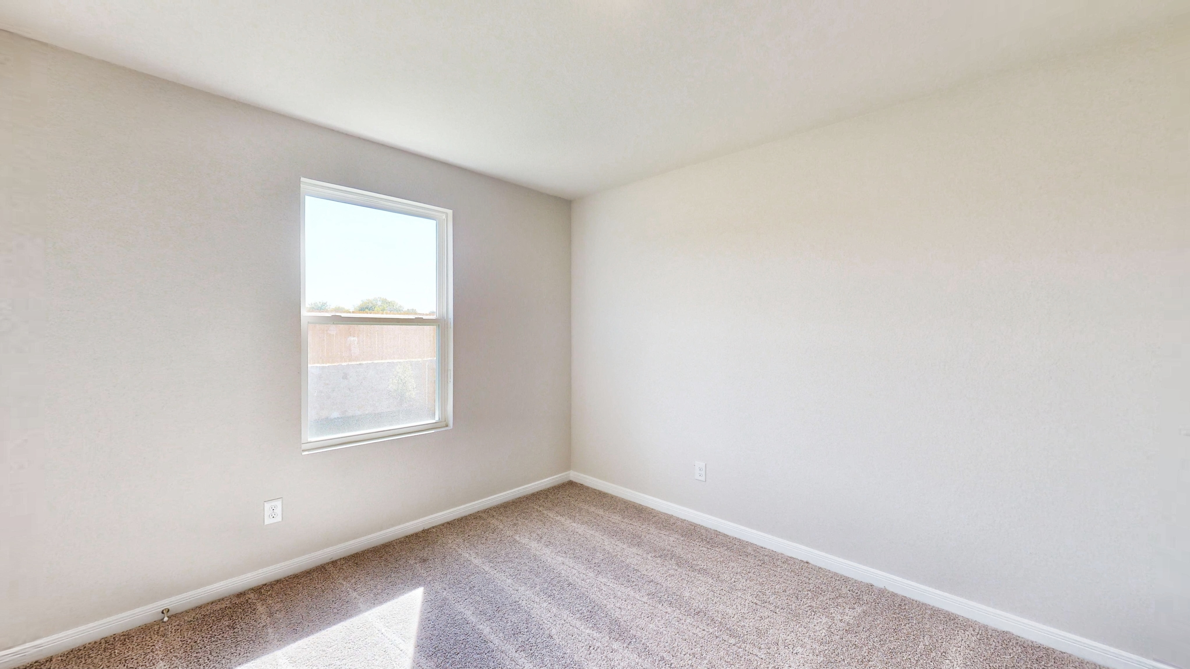A room with a window and carpet.