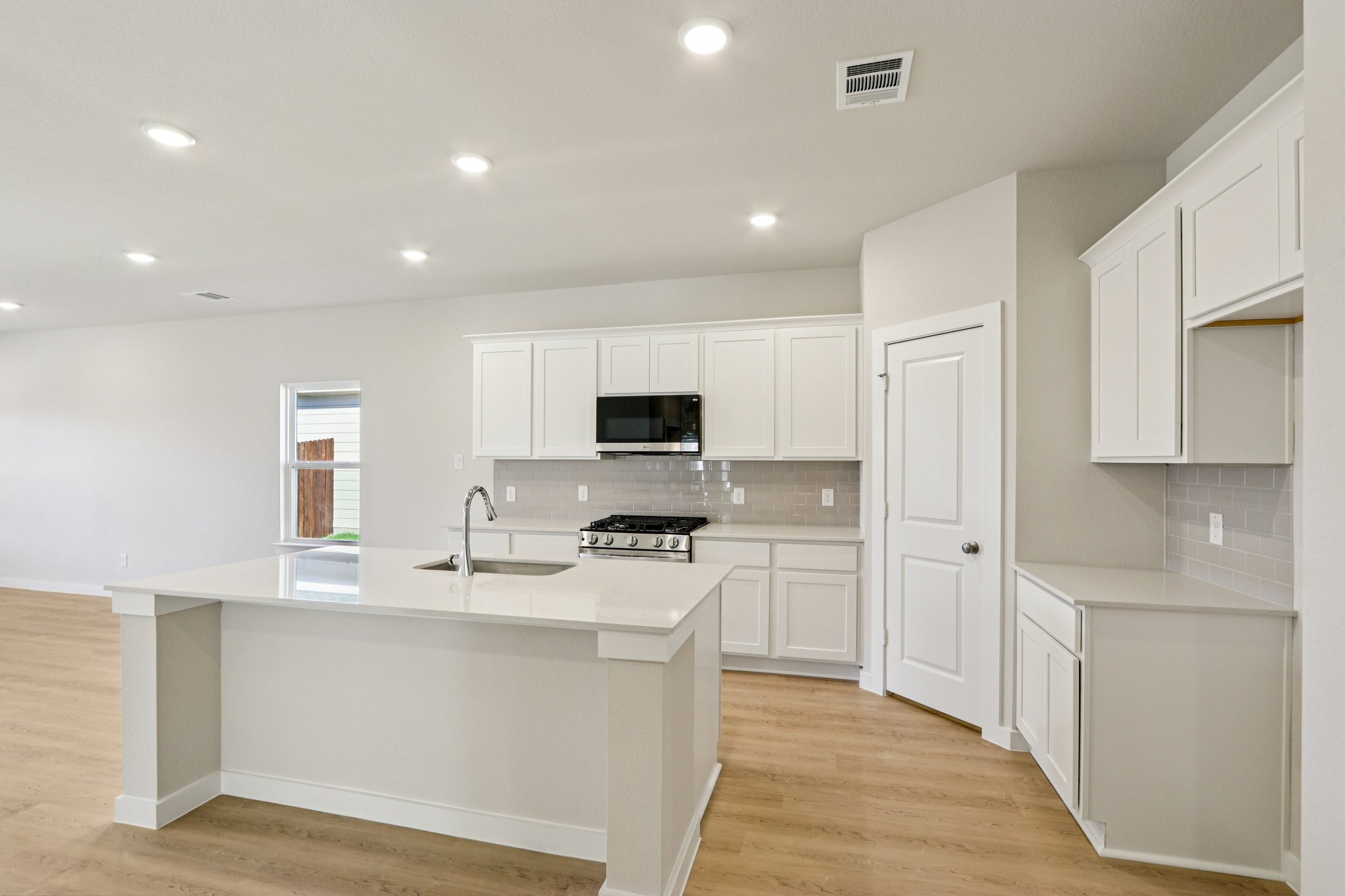 A kitchen with white cabinets.