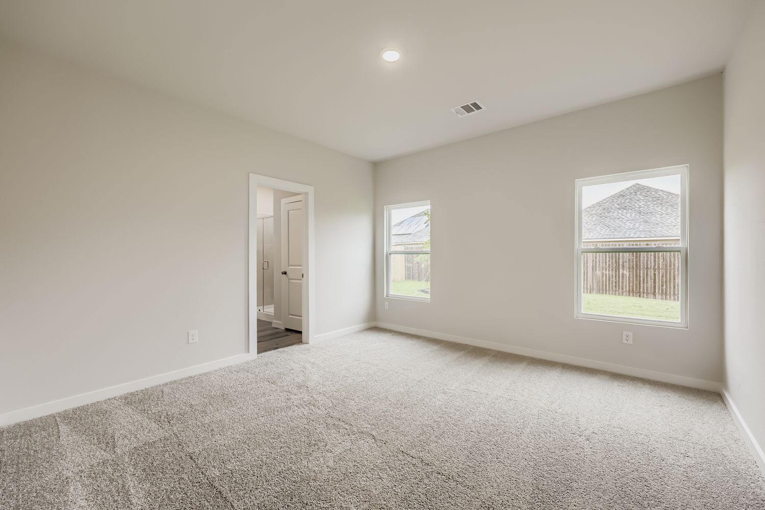 A room with a carpet and windows.