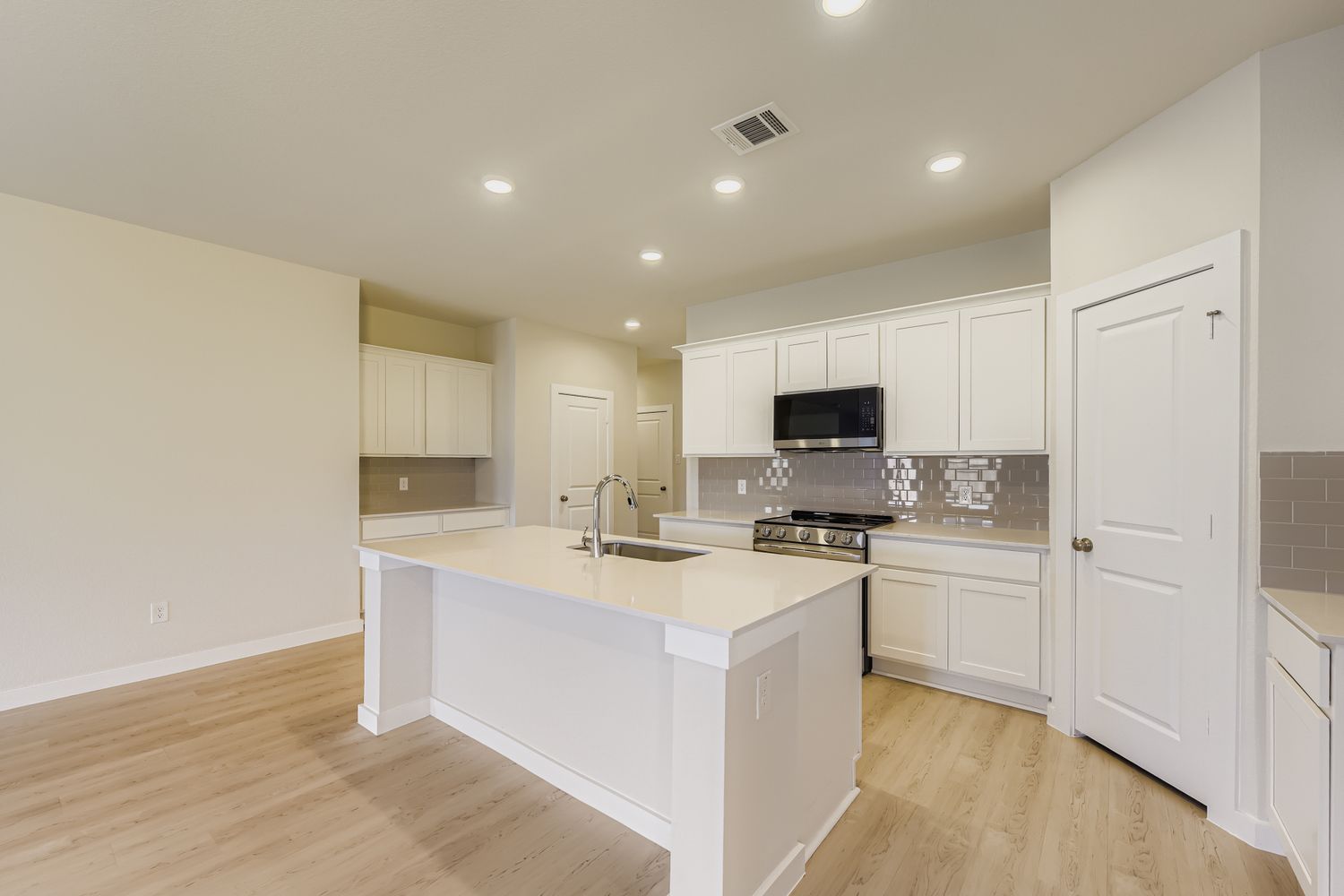 A kitchen with white cabinets.