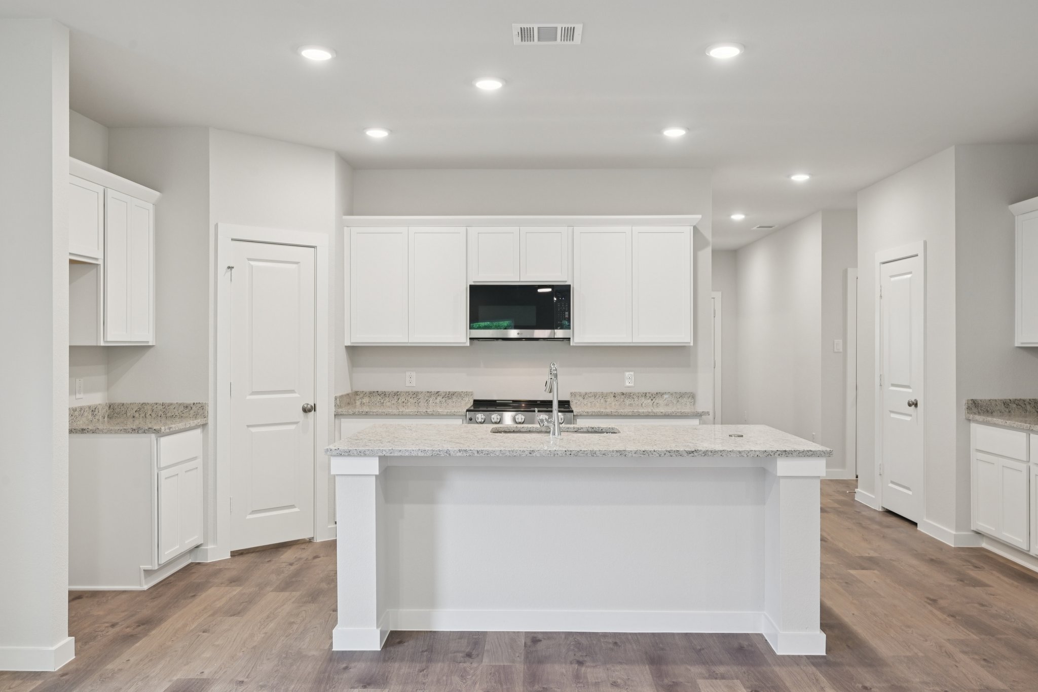 A kitchen with white cabinets.