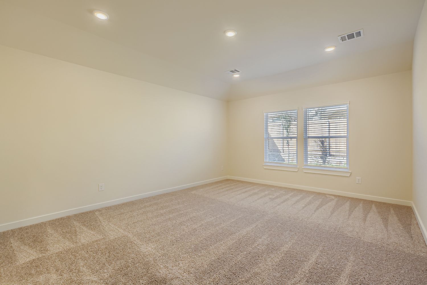 A room with a carpet and a window.