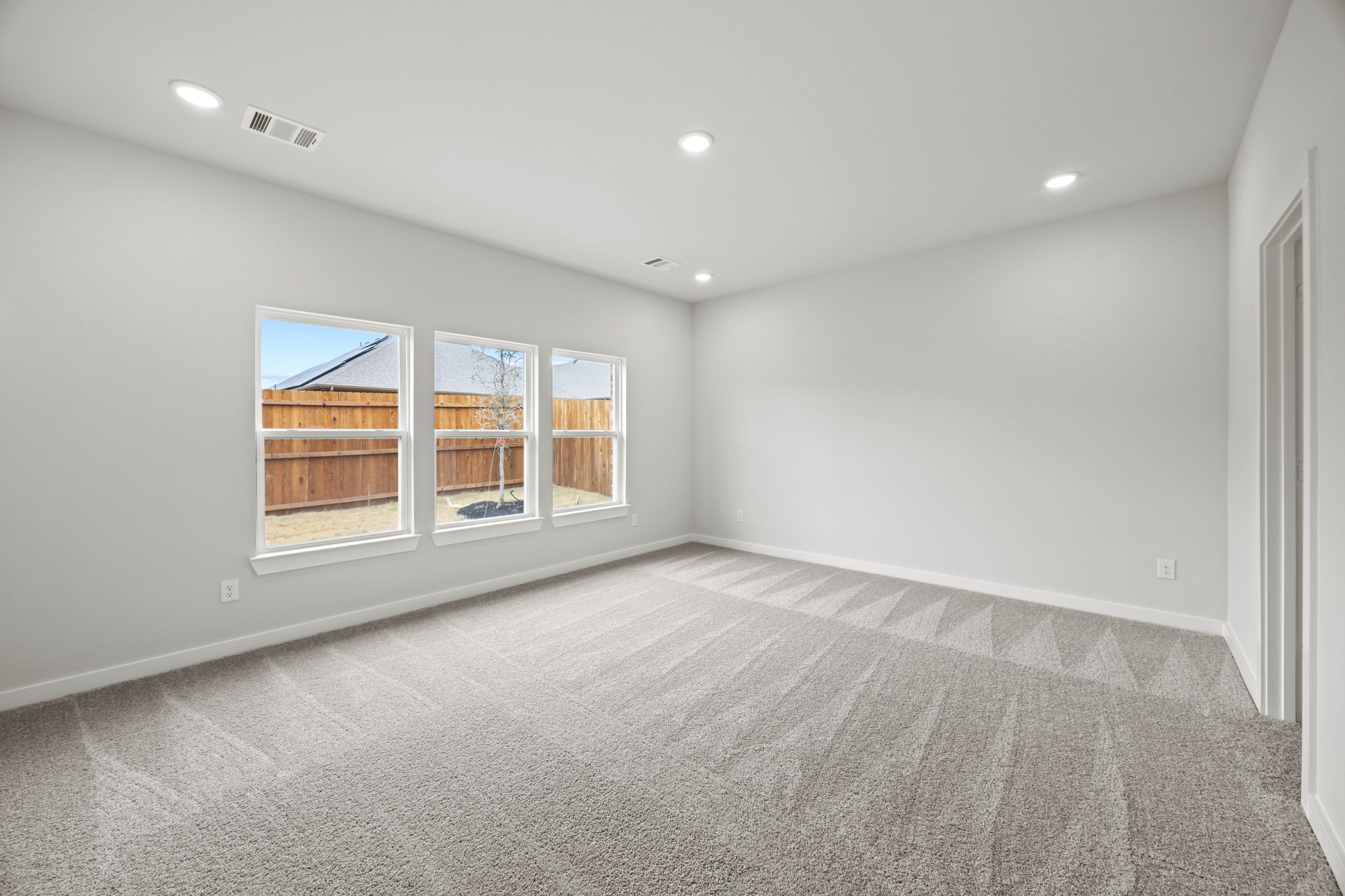 A room with a carpet and windows.