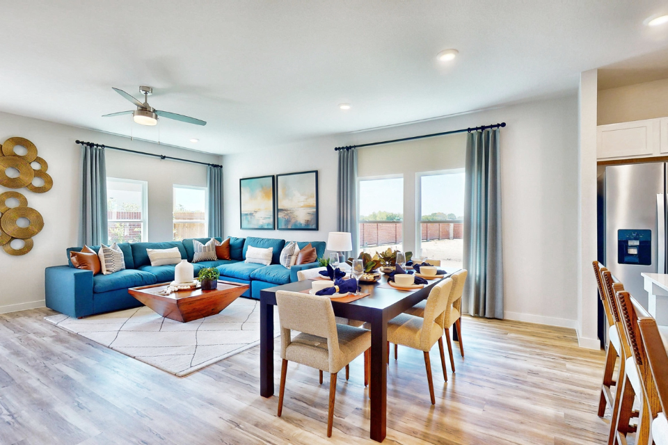 A living room with a blue couch and a table.