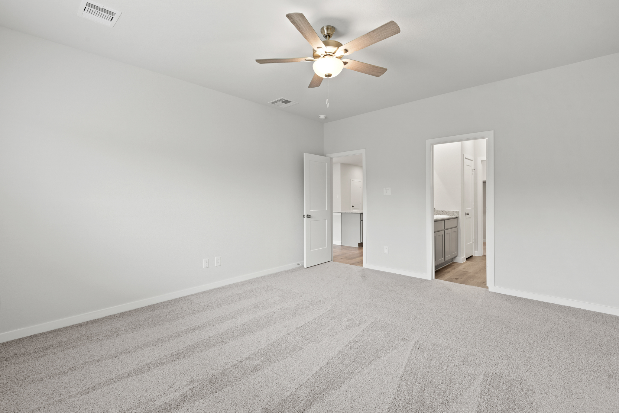 A room with a ceiling fan and a door.