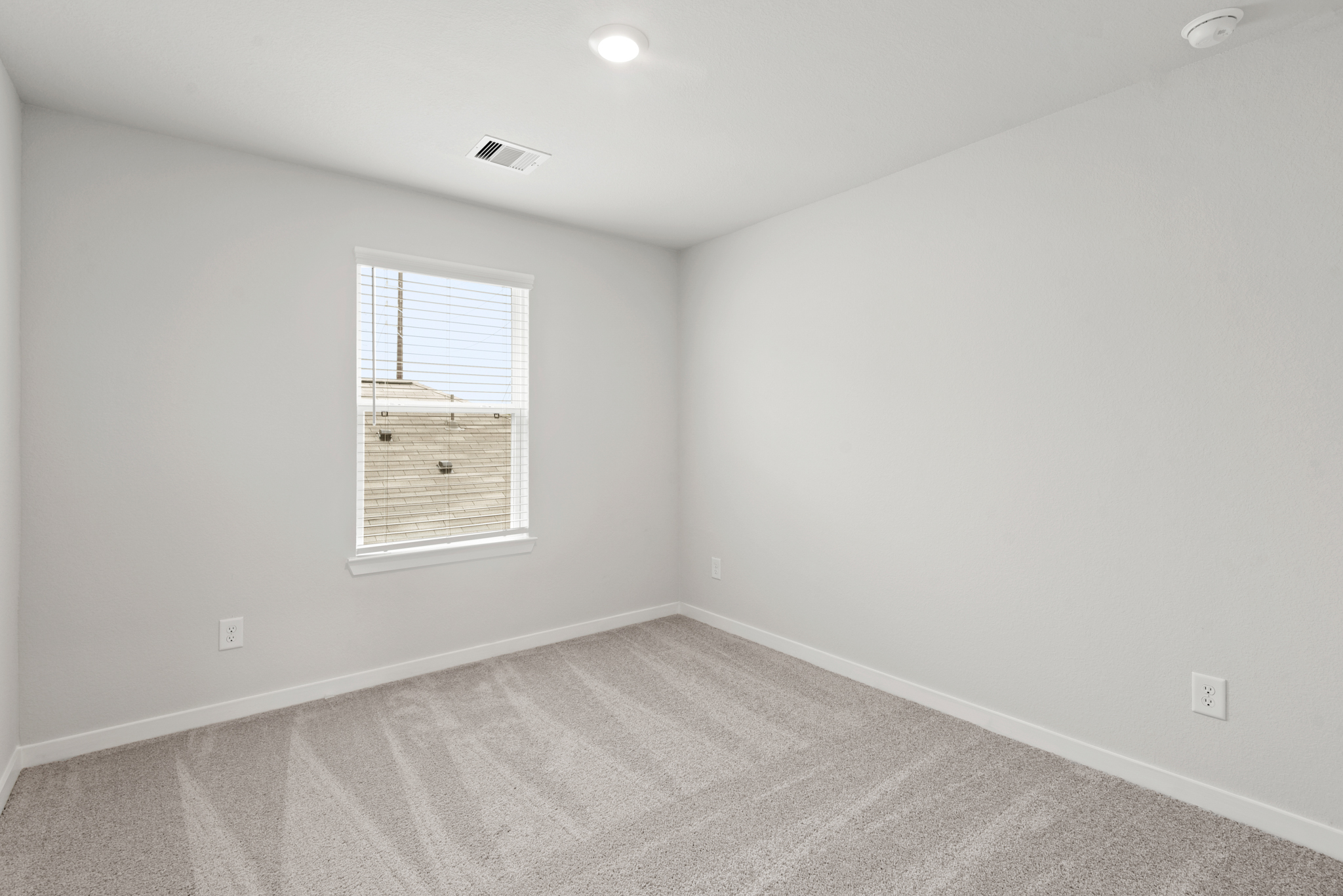 A room with a window and a rug.