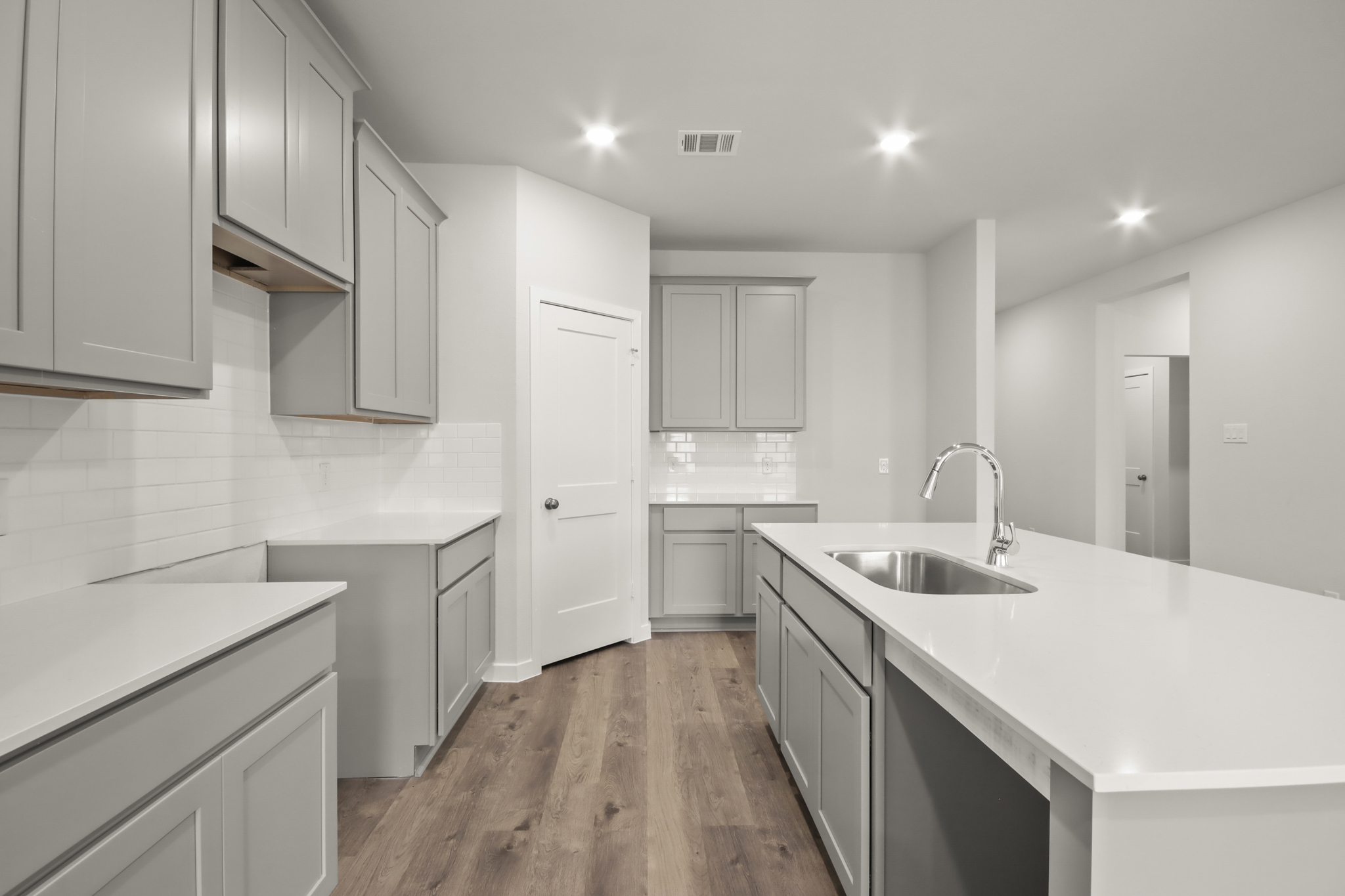 A kitchen with white cabinets.