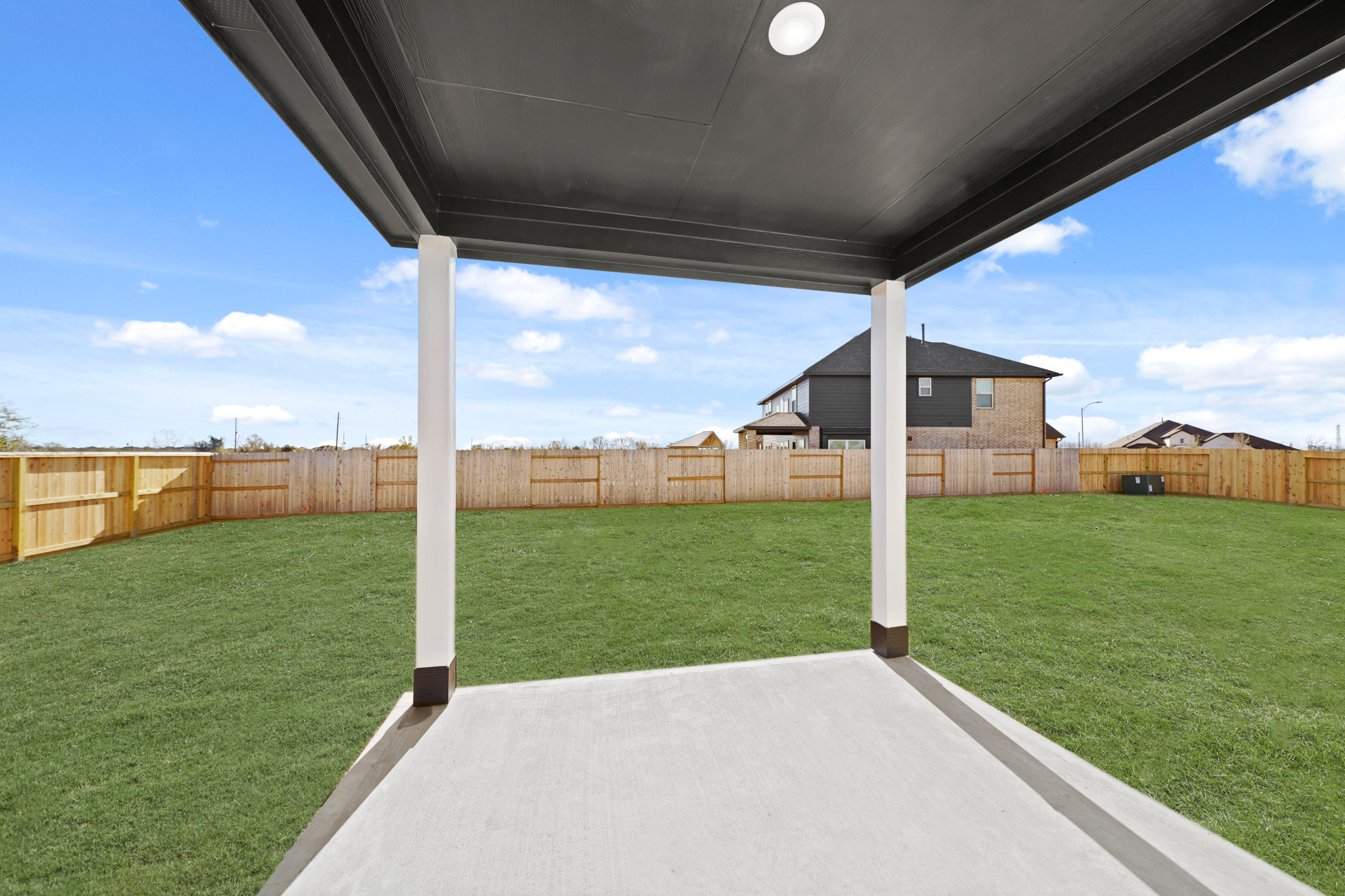 A walkway with grass and a fence.
