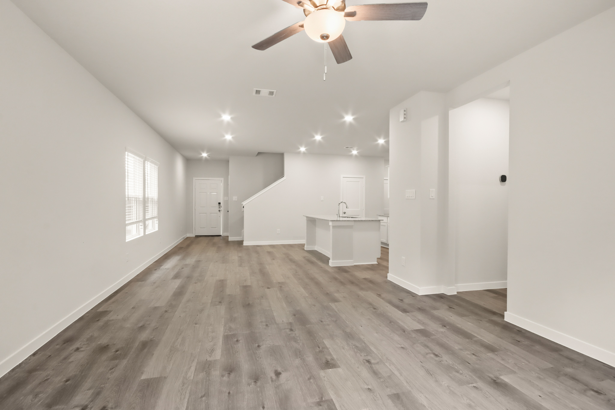 A room with a wood floor and a ceiling fan.