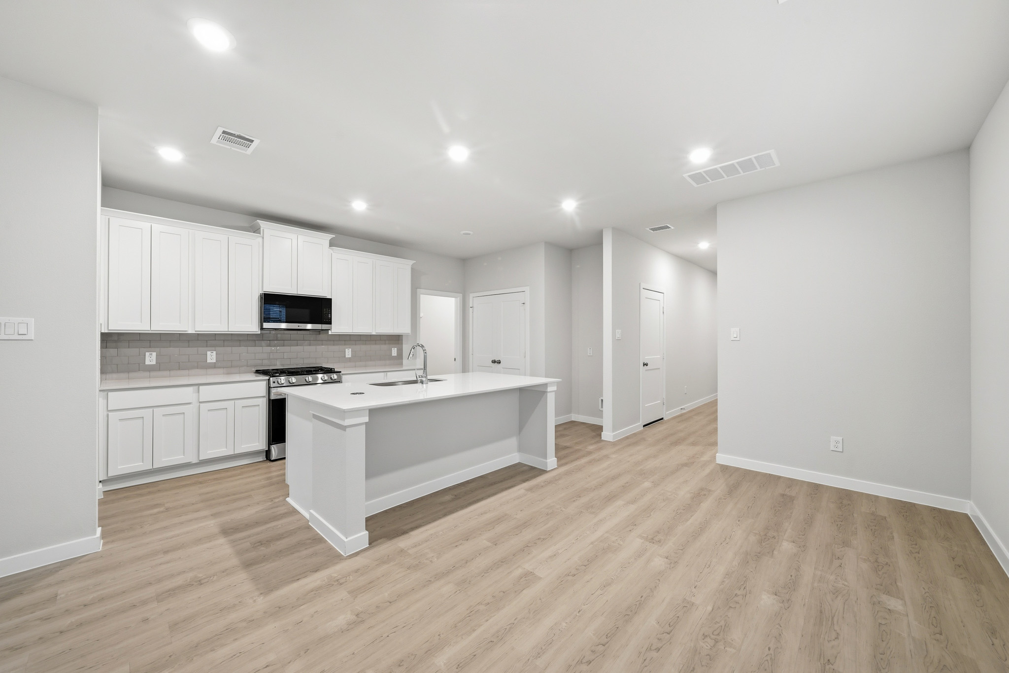 A kitchen with white cabinets.