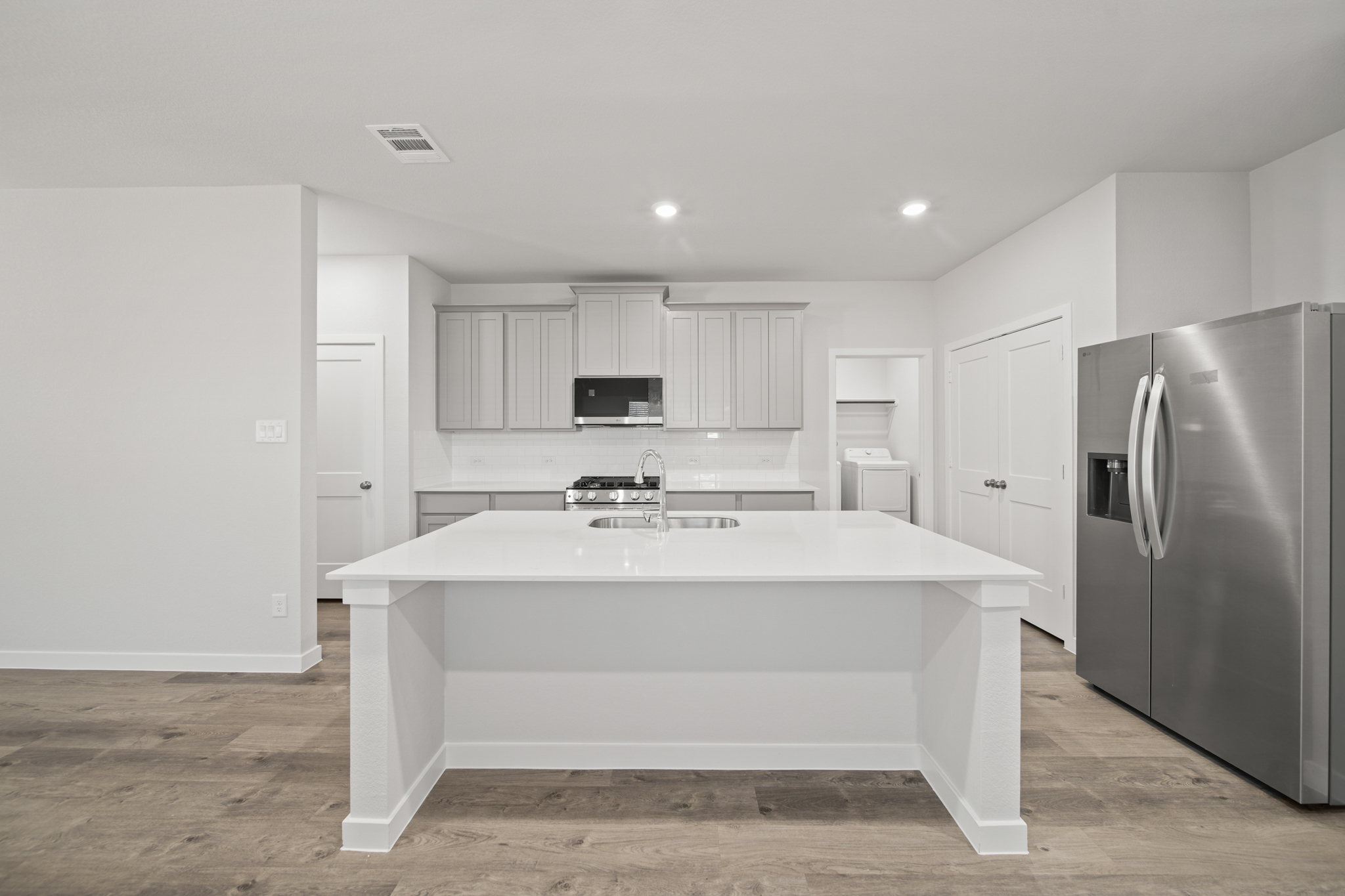 A kitchen with white cabinets.
