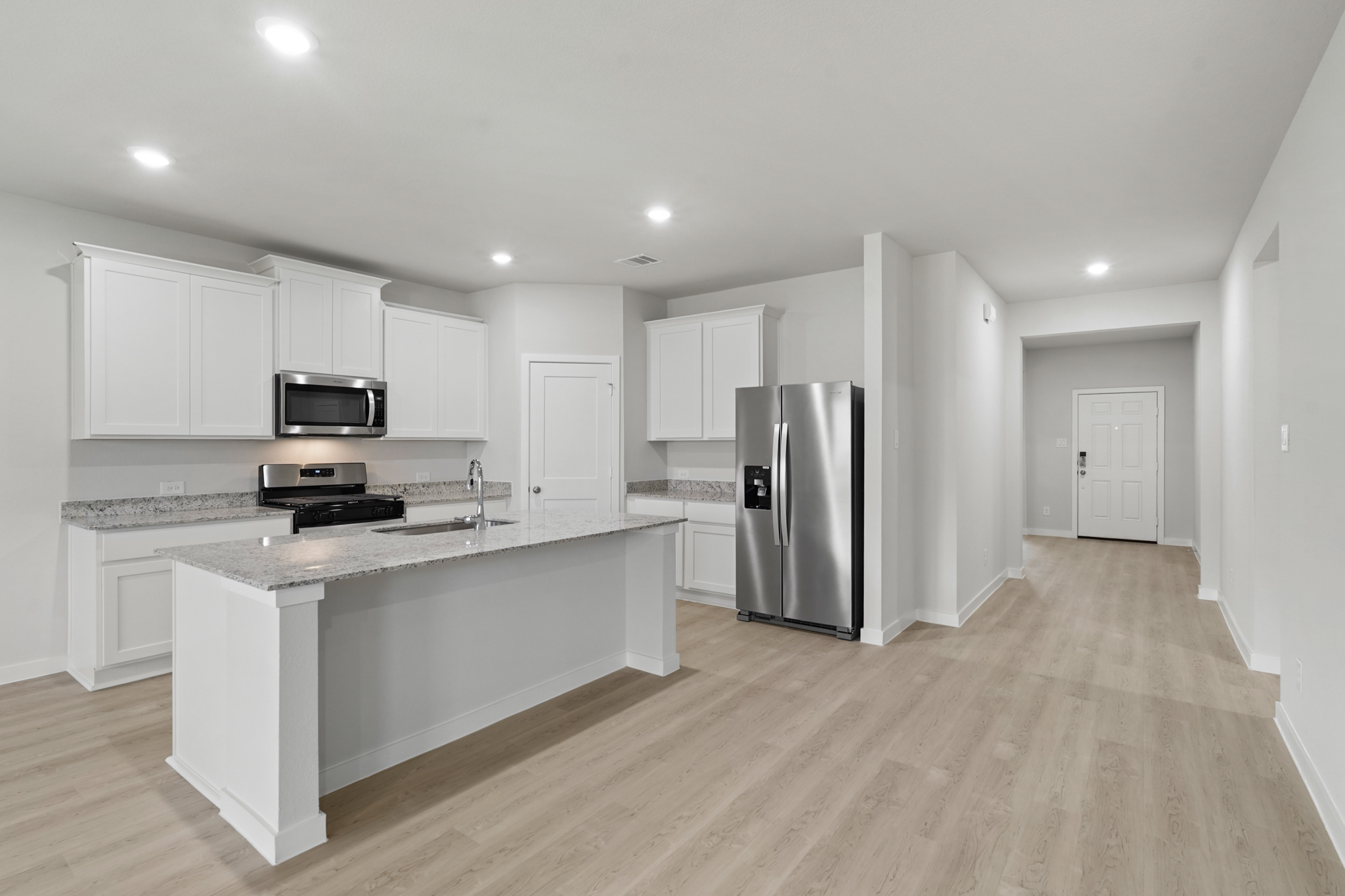 A kitchen with white cabinets.