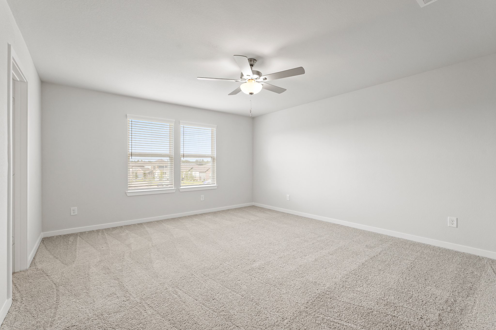 A room with a ceiling fan and a window.