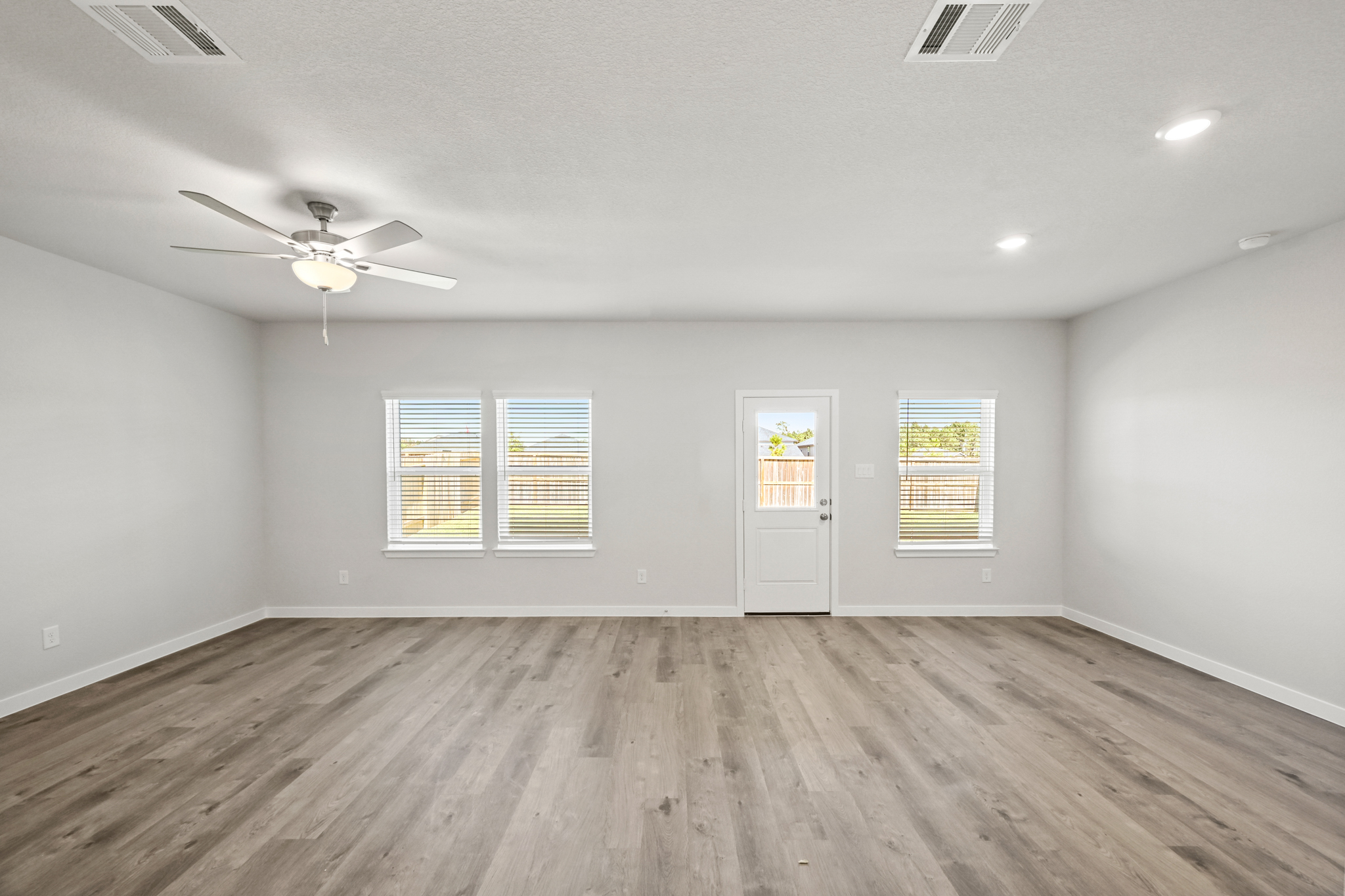 A room with a wood floor and a ceiling fan.