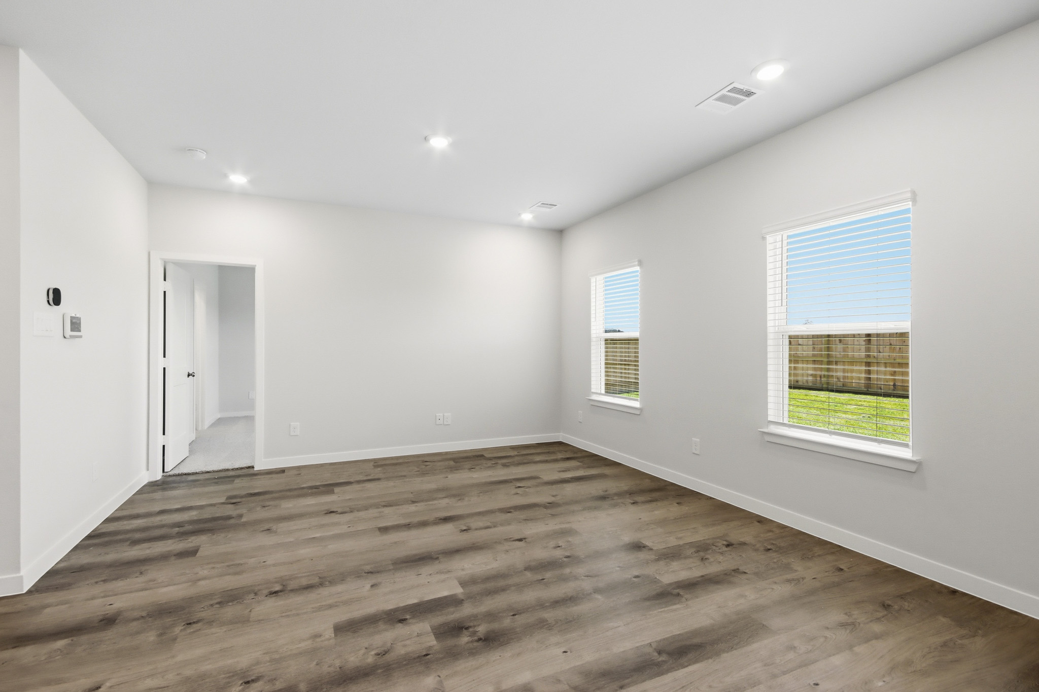 A room with a wood floor and windows.