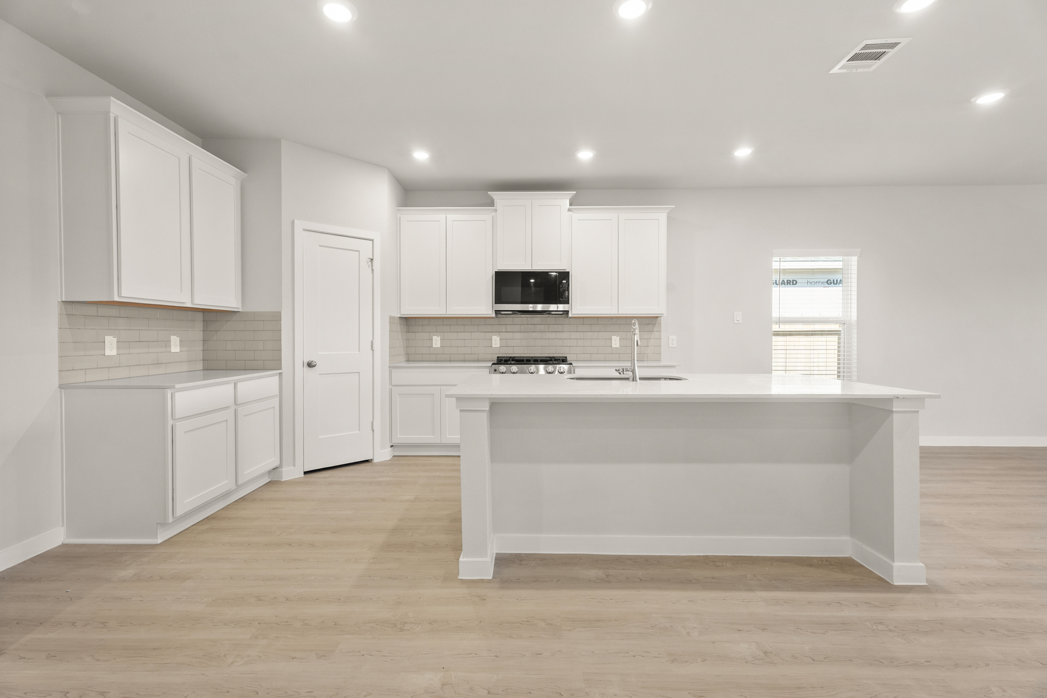 A kitchen with white cabinets.