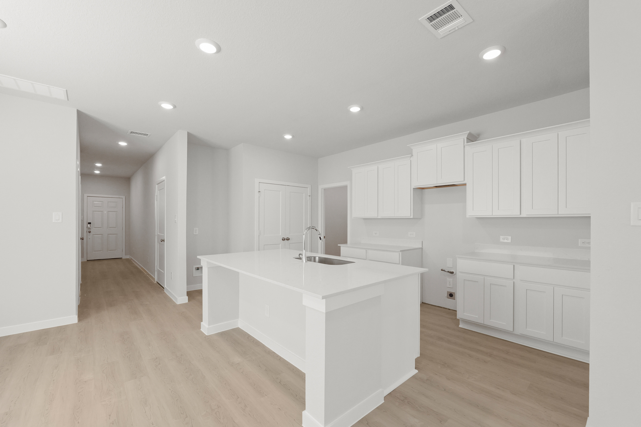 A kitchen with white cabinets.