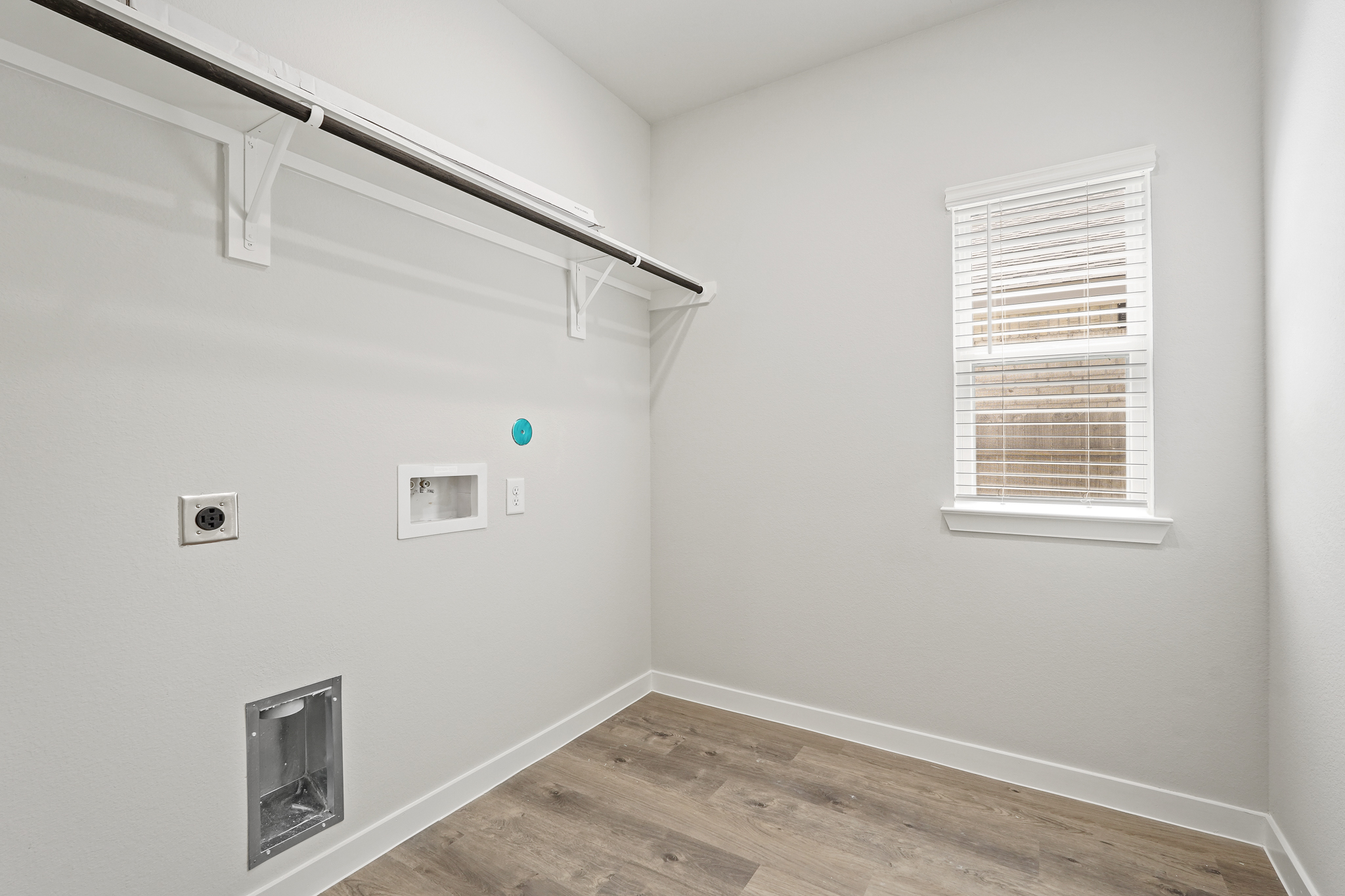A room with a wood floor and a wood floor with a window.