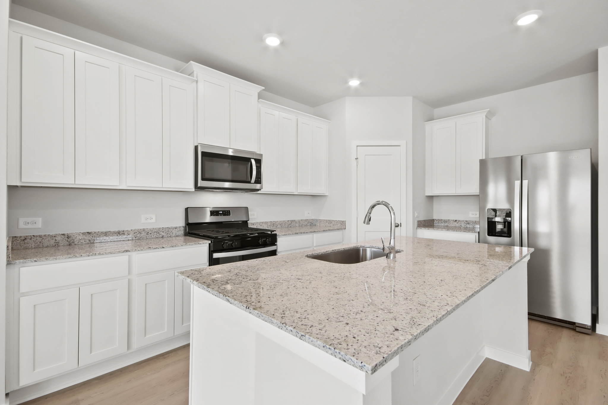 A kitchen with white cabinets.