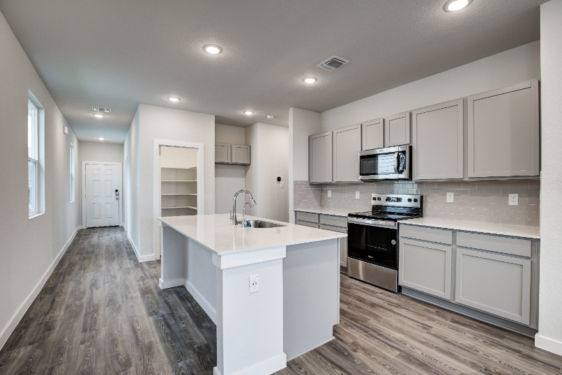 A kitchen with white cabinets.