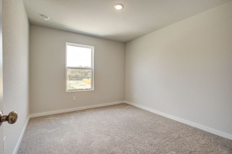 A room with a window and carpet.