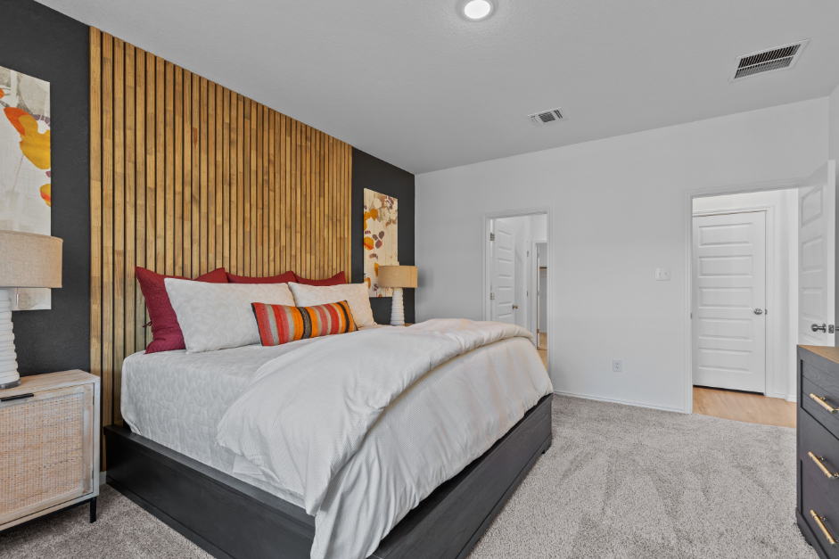 A bedroom with a bed and a lamp.