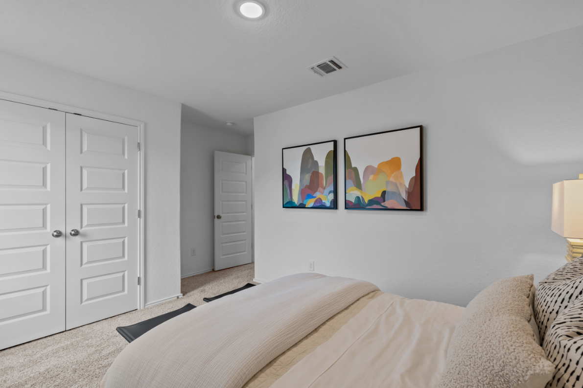 A bedroom with a bed and a painting on the wall.