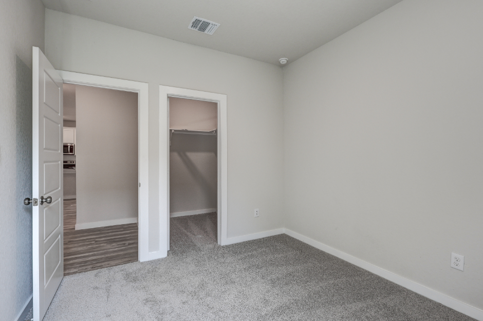 A room with a door and a closet.