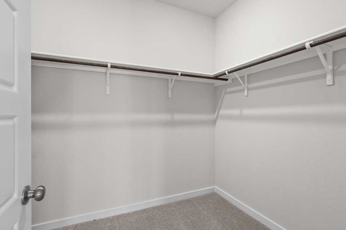 A white wall with a metal bar.