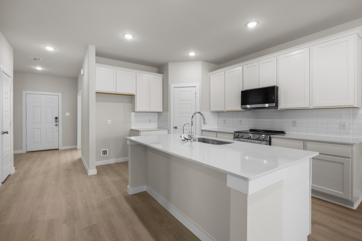 A kitchen with white cabinets.