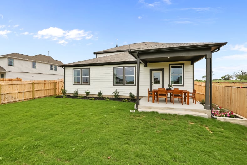 A house with a fence and lawn.
