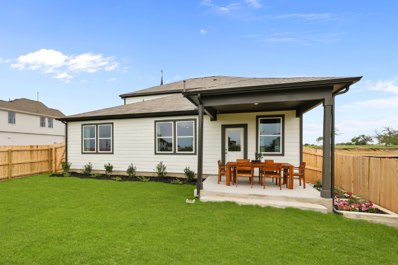A house with a fence and lawn.